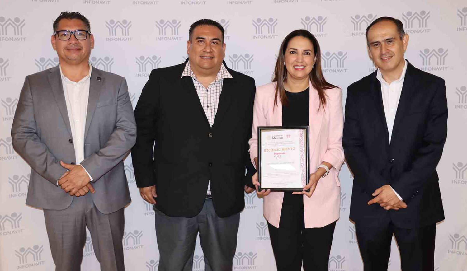 la mtra tania casillas y el lic mario contreras con el distintivo otorgado por el infonavit